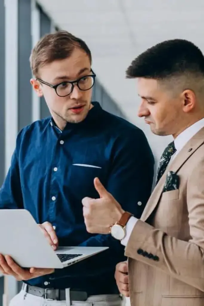 two-male-colleagues-office-standing-with-laptop